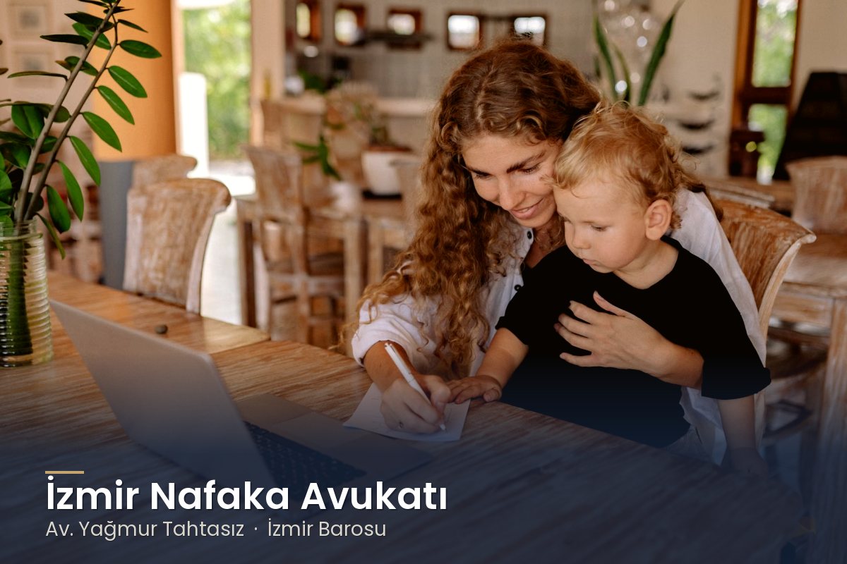 Kucağında çocuğuyla bilgisayardan hesaplarını kontrol eden anne – İzmir nafaka avukatı Av. Yağmur Tahtasız