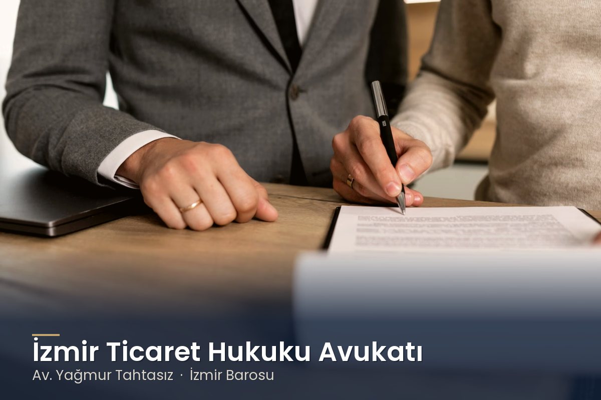 Toplantı masasında sözleşme imzalayan iki kişi – İzmir ticaret hukuku avukatı Av. Yağmur Tahtasız